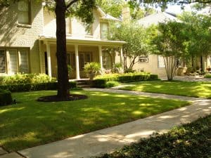large home with long walkway and maintained lawn in the shade
