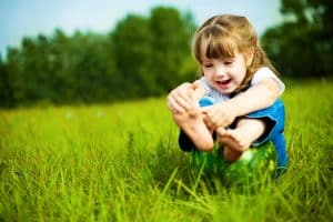 girl playing with her foot in a field